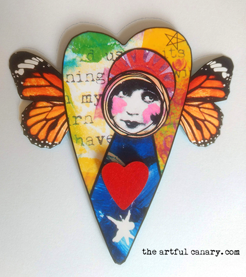 A Heart with butterfly wings holding a colorful painted art angel.
